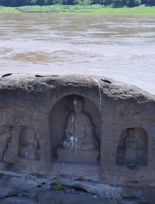 宇轩配资 长江重庆段水位下降露出600年历史石佛，许多游客隔岸参观祈福